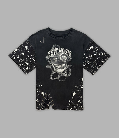 Black t-shirt with graphic design and splatter paint effect on a gray background