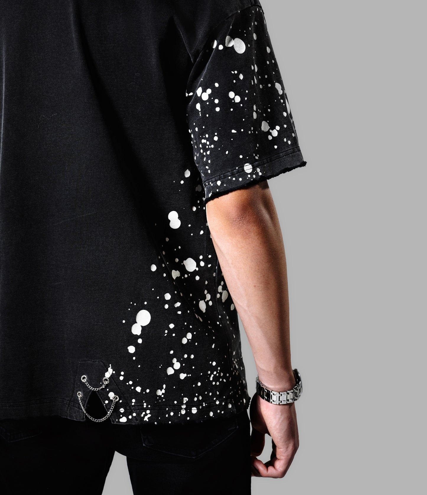 Black t-shirt with white splatter design on a gray background