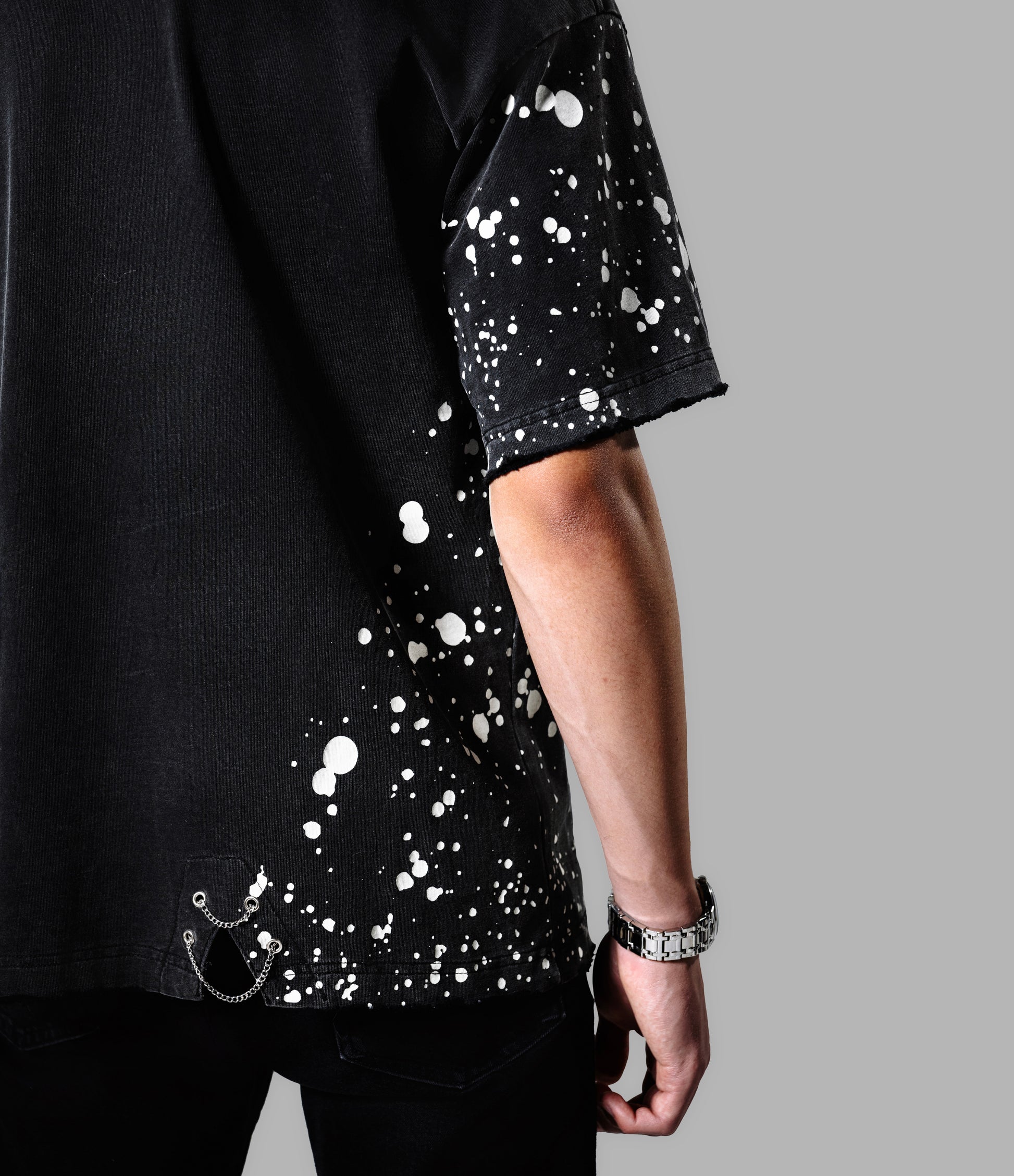 Black t-shirt with white splatter design on a gray background